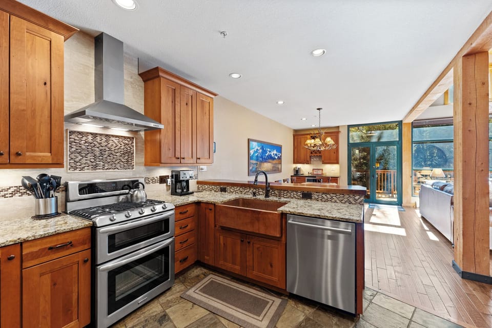 Your fully-equipped gourmet kitchen features granite counters, stainless appliances, and stunning mountain views while you cook.