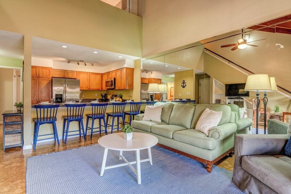 Open living area with vaulted ceilings, warm natural light, and a seamless flow into the kitchen and dining space.