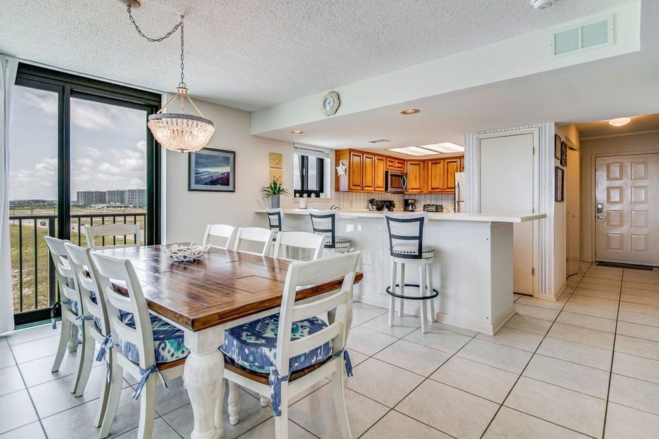 Dining table seats 8 guests at Wind Drift Orange Beach family-friendly condo