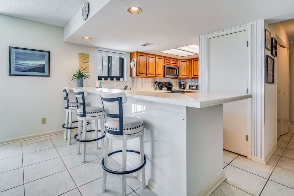 Open dining and living area with Gulf views at Wind Drift Orange Beach