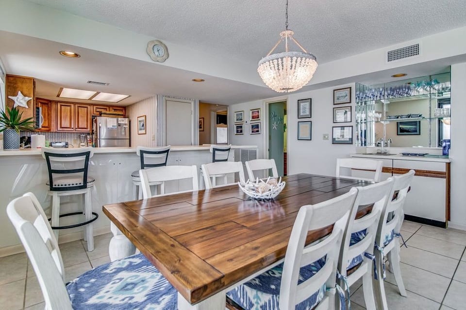 Dining table seats 8 guests at Wind Drift Orange Beach family-friendly condo