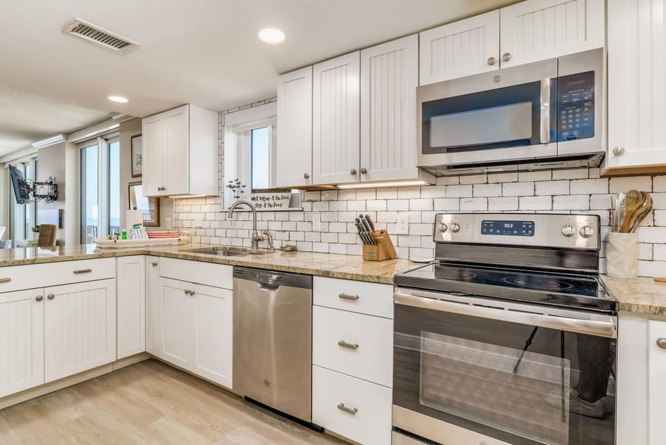 Kitchen with stainless appliances and granite island at Wind Drift Orange Beach