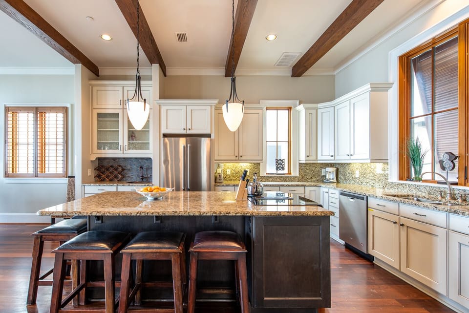 Kitchen Island with Stools, Refrigerator, and Dishwasher.