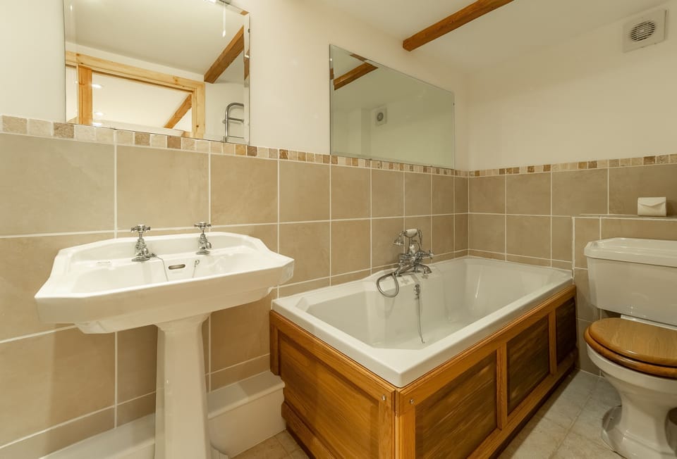 The Threshing Barn, Truro. Ground floor: Bedroom two en-suite with bath, shower, wash basin and WC