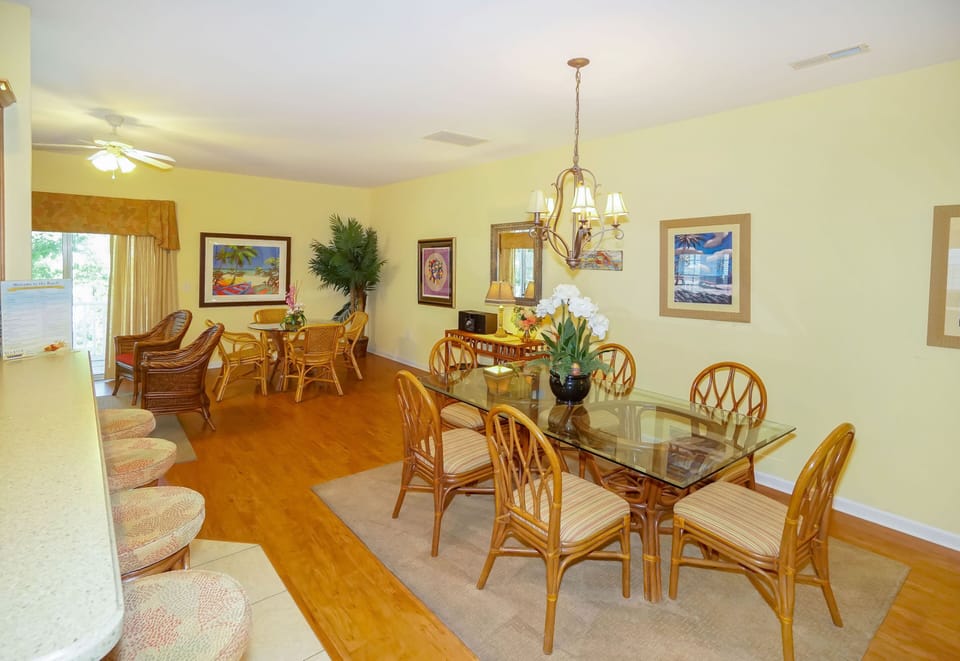 Your spacious dining room features elegant rattan furniture and warm tropical artwork, perfect for memorable meals together.