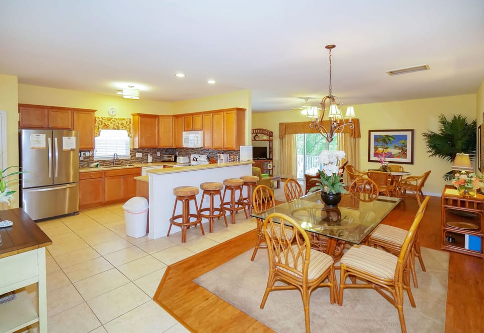 Gather around the spacious kitchen island for morning coffee or prepare tropical meals in your fully equipped kitchen with warm wood cabinetry.