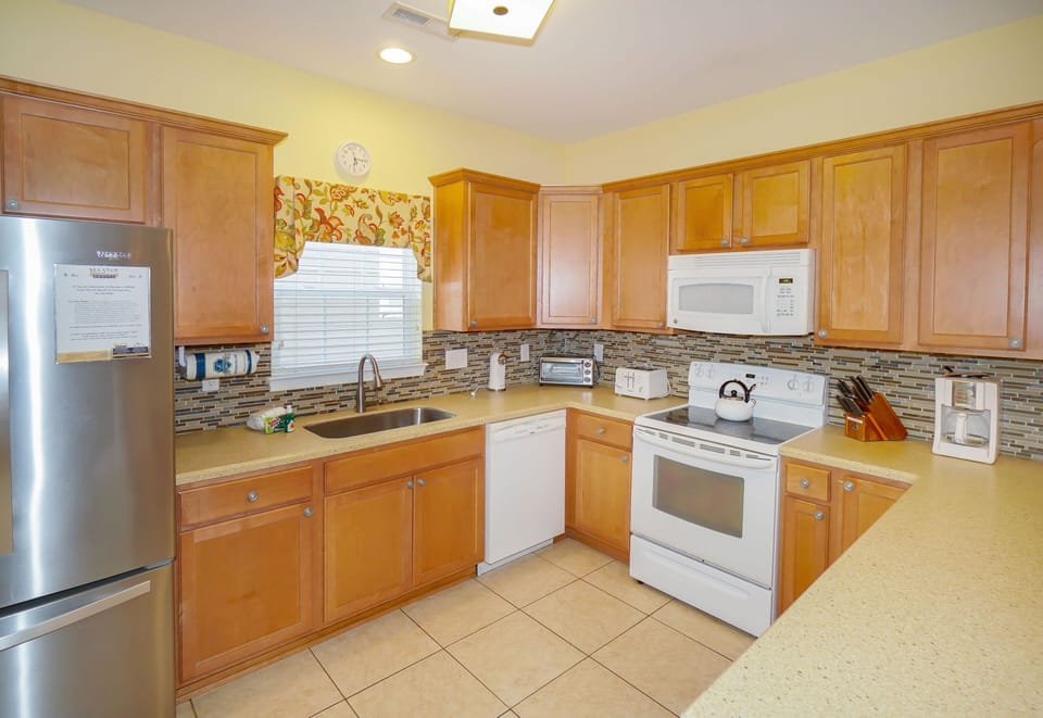Your fully-equipped kitchen features warm wood cabinetry, modern appliances, and elegant granite countertops—perfect for preparing memorable meals during your stay.