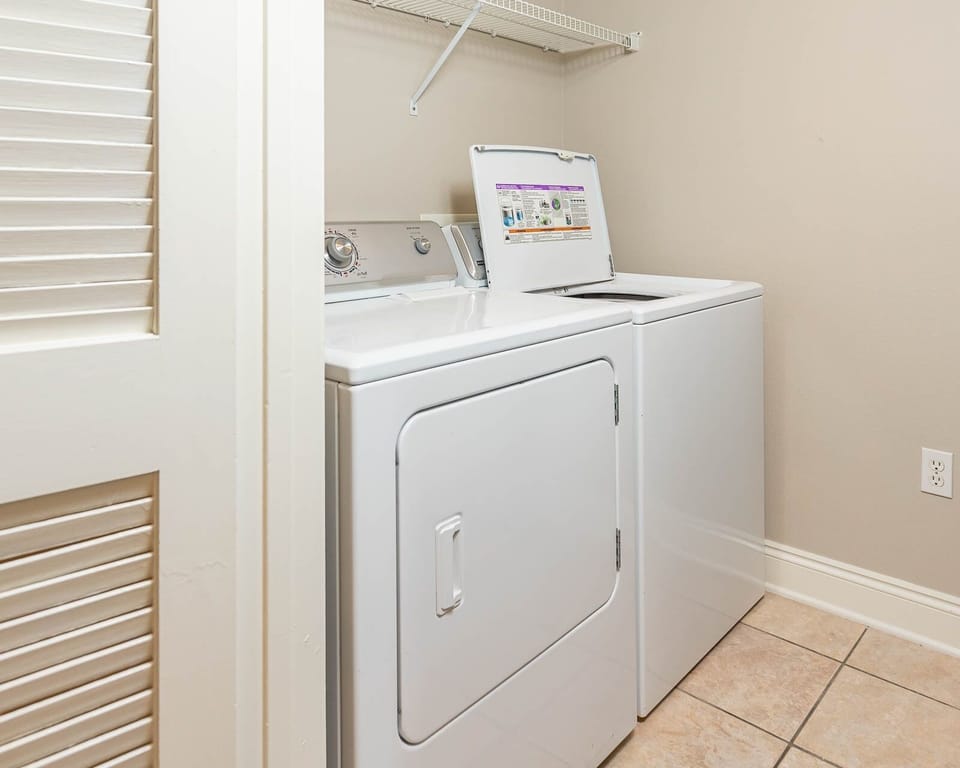 Laundry area featuring a washer and dryer with ample shelf space above for convenience and organization