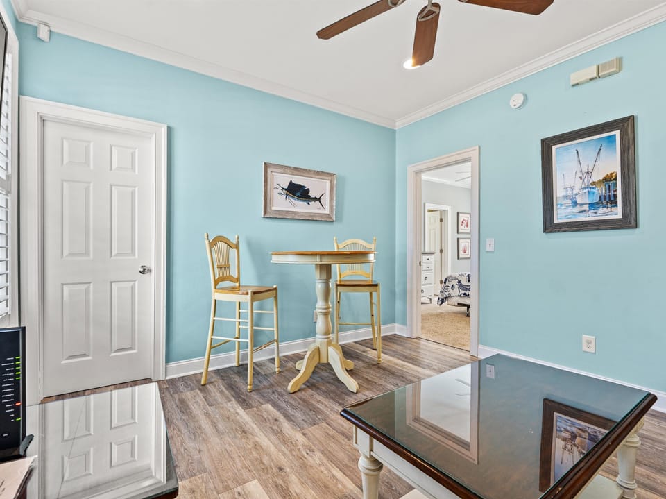 Step into your charming coastal dining nook with cheerful blue walls and nautical artwork that sets the perfect seaside mood for morning coffee.