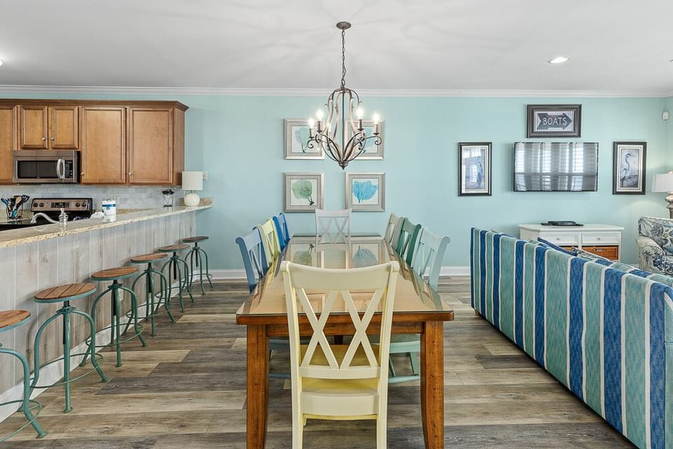 Gather around your spacious dining table for meals while coastal artwork and soothing blue tones create the perfect seaside atmosphere.