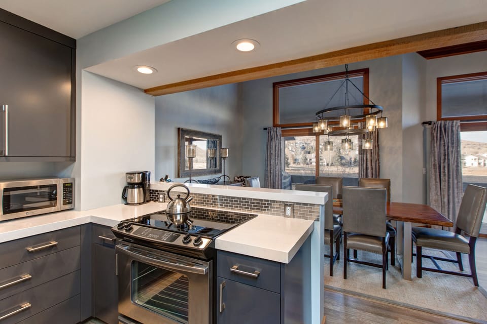 Fully Equipped Kitchen with Stainless Steel Appliances, Quartz Countertops, and Bar Seating for 3