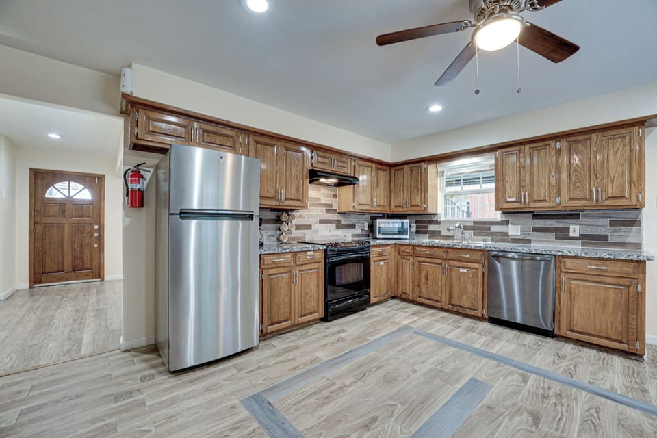 Kitchen with full size fridge, cooking range, dish washer, micro oven, toaster.
