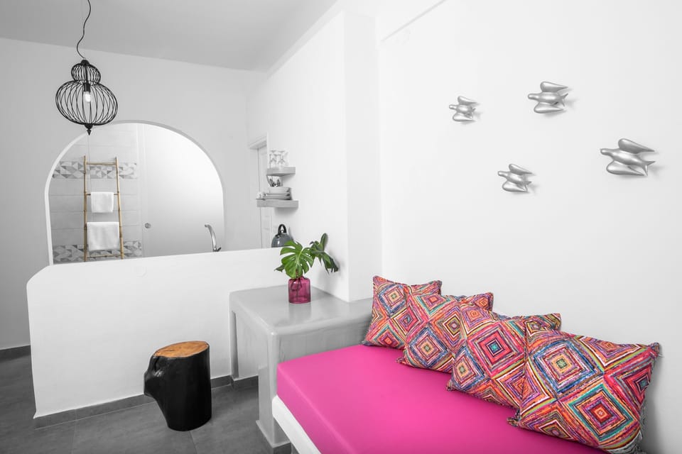 Deluxe Double room with Caldera View | Living area | Flat-screen TV, books