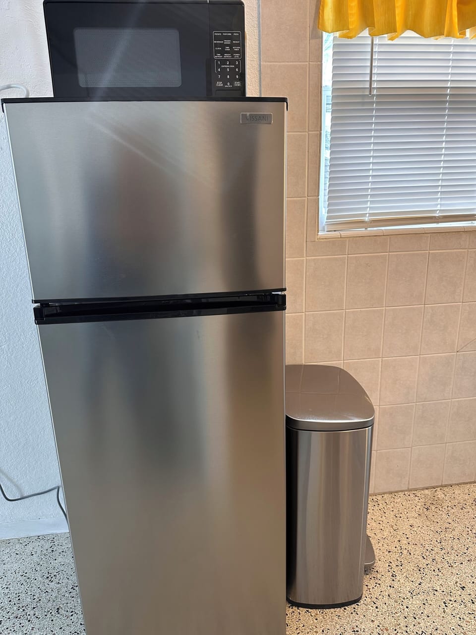 Refrigerator and trash can.