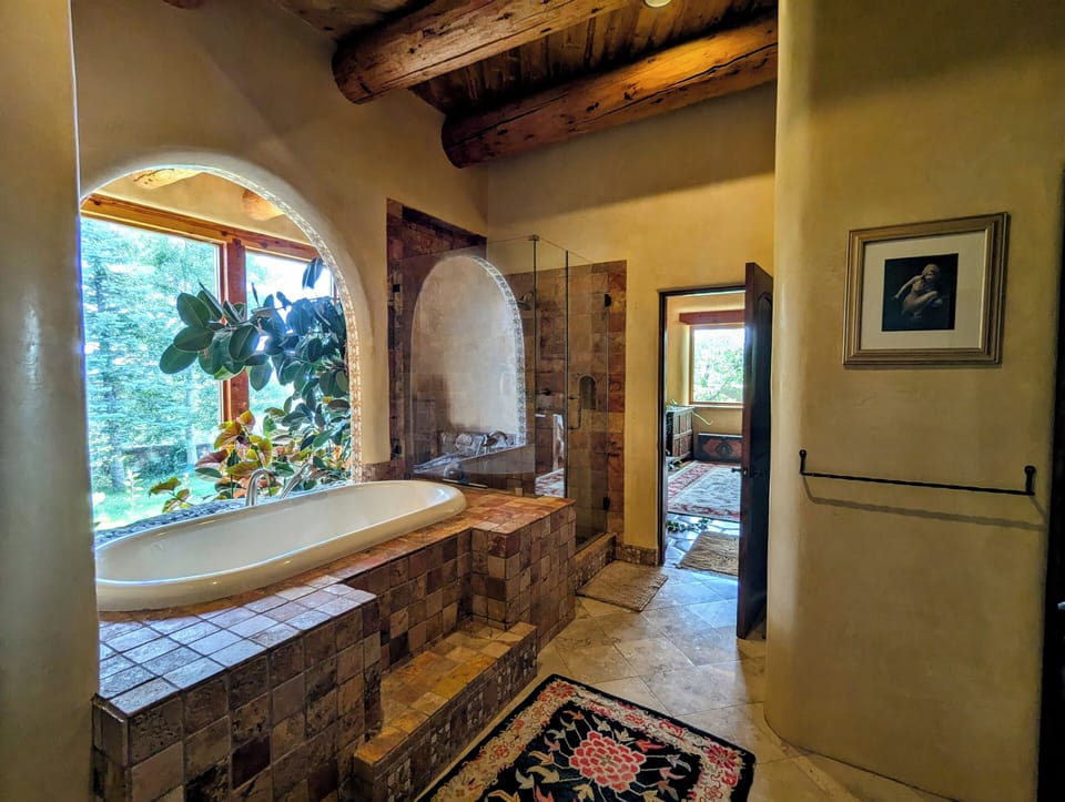 En-suite with soaking tub, glass enclosed shower & greenroom views