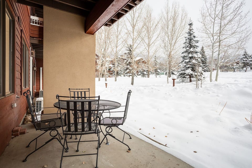Step onto your private patio where mountain air meets cozy seating, perfect for morning coffee overlooking the pristine winter landscape.