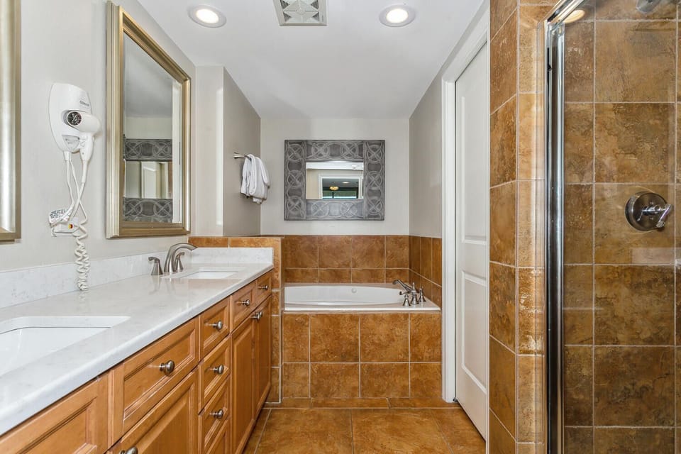 Refresh in your spa-inspired bathroom with a soaking tub, dual-sink vanity, and separate walk-in shower finished with warm tile.