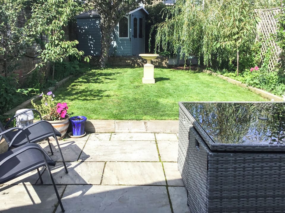 Paved patio area with furniture overlooking the garden | The Cottage By The Sea Annexe - The Cottages by the Sea, Littlehampton, near Arundel