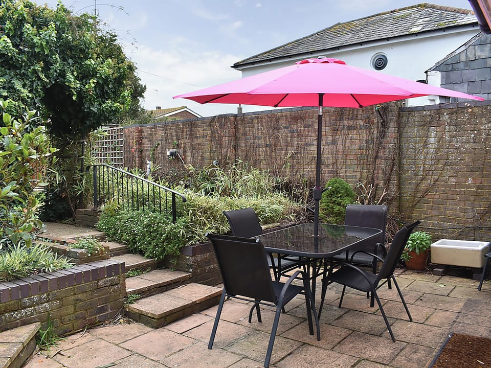 Paved patio area with steps up to the garden | The Cottage by the Sea - The Cottages by the Sea, Littlehampton, near Arundel