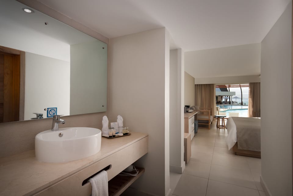 Junior Swim Up Room, Ocean View | Bathroom | Shower, rainfall showerhead, hair dryer, bathrobes