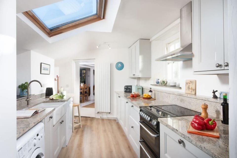 Roseneath, St Agnes. Ground floor: Kitchen with an oven and hob, microwave, fridge freezer and dishwasher