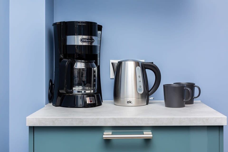 A coffee and tea station complete with a coffee maker, kettle, and a selection of beverages for guests.






