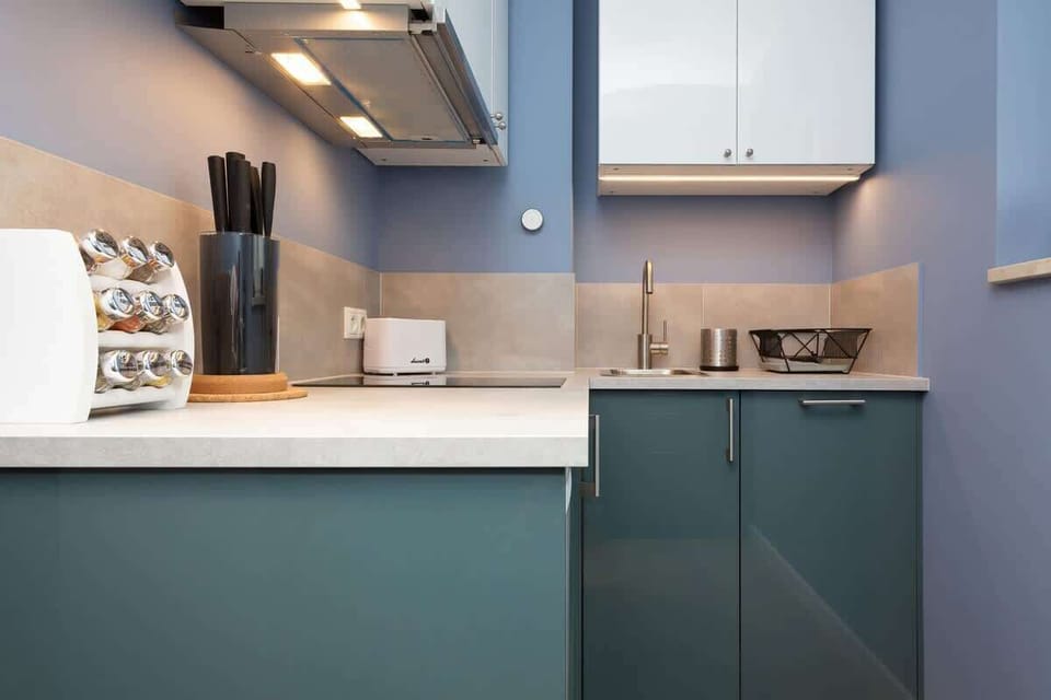 Another perspective of the kitchen, showing its layout and stylish blue cabinetry.