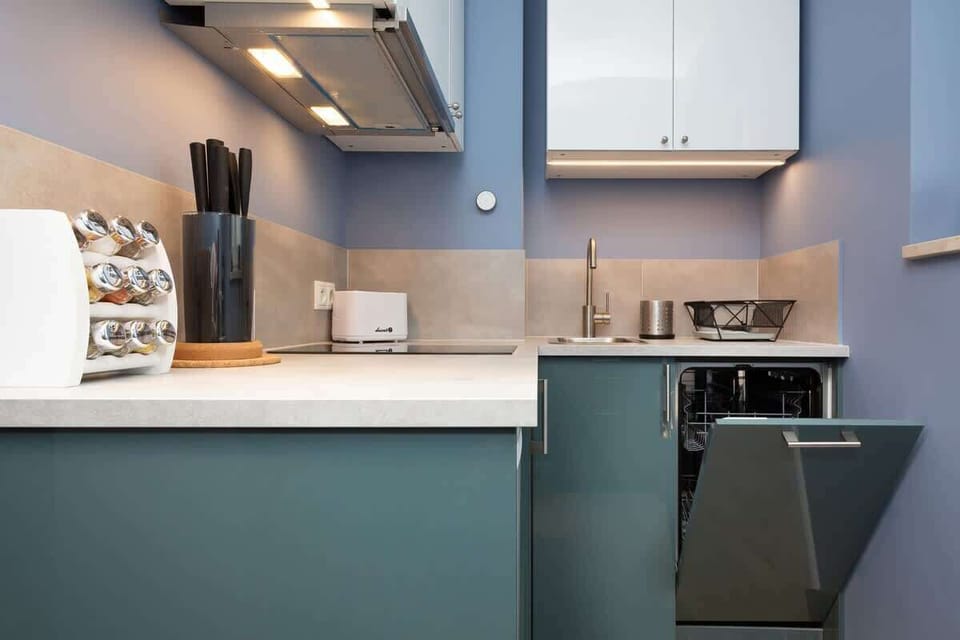A functional kitchen space with sleek blue cabinetry, a built-in oven, and essential appliances for cooking and dining.