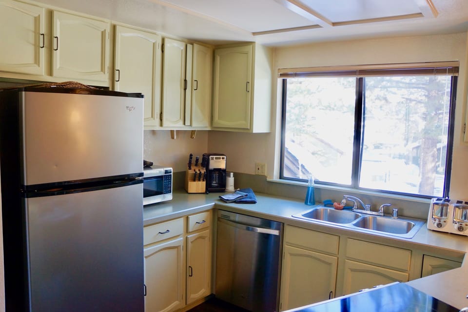 View into kitchen, primary living/dining area with full bath, all on 2nd floor. 