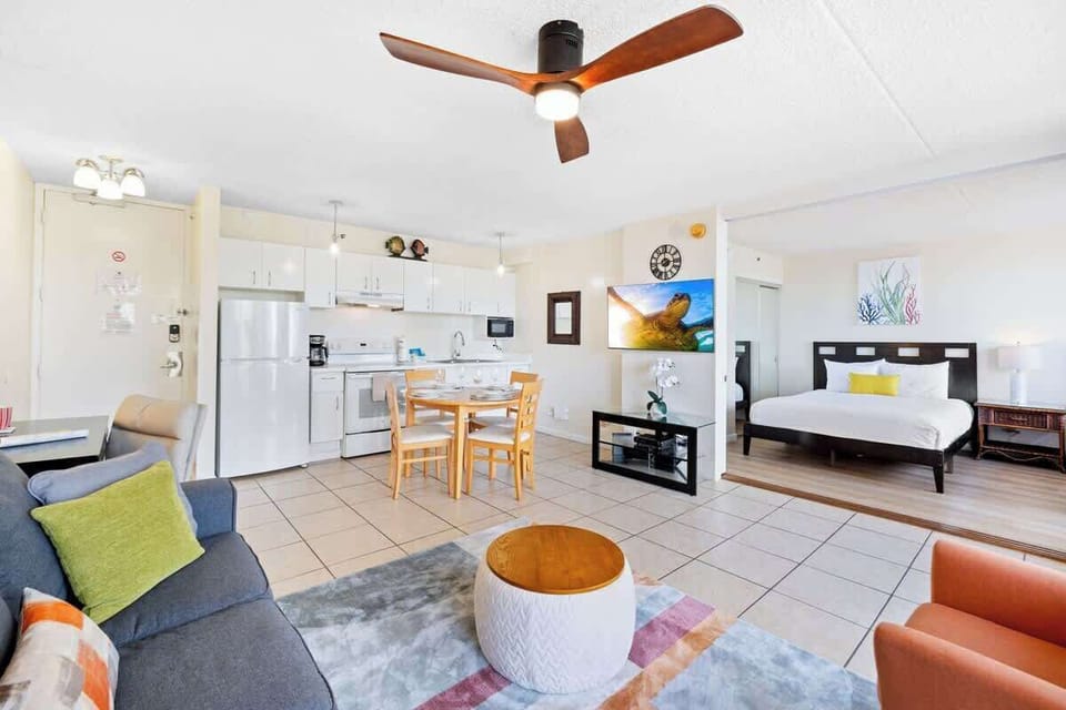 Living room with pull-out sleeper sofa, smart TV, a fan, a coffee table, and a comfortable chair.