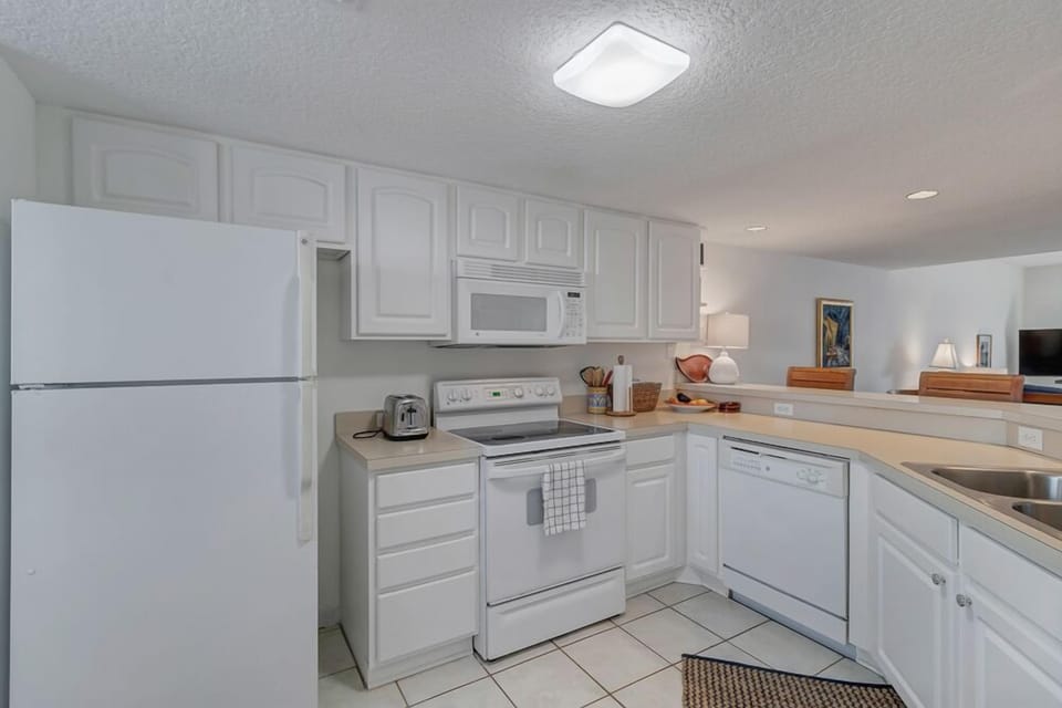 - Enjoy a bright and fully equipped kitchen with sleek white appliances and cabinets
- Open layout lets you cook and connect with guests at the same time
- Stove, dishwasher, microwave, and fridge all ready for your stay