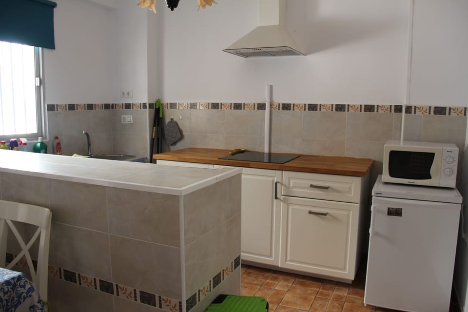 Kitchen with fridge, stove, microwave, coffee maker and kettle