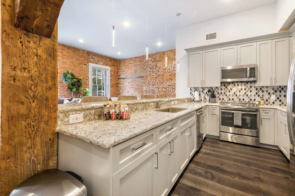 Cook and dine in the fully stocked kitchen with stainless steel appliances, gas range, basic cookware, and a dining area for a comfortable meal. Entertain at the bar with seating for four.