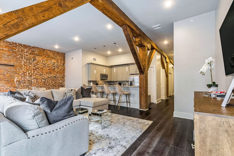 Open concept living, kitchen, and dining area with ample seating. Stream on 65” Samsung Smart 4K TV with DIRECTV. Relax on the large sectional and dine at a table for six with bar seating for four and plenty of natural light.