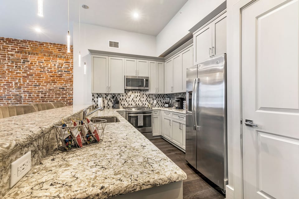 Cook and dine in the fully stocked kitchen with stainless steel appliances, gas range, basic cookware, and a dining area for a comfortable meal. Entertain at the bar with seating for four.