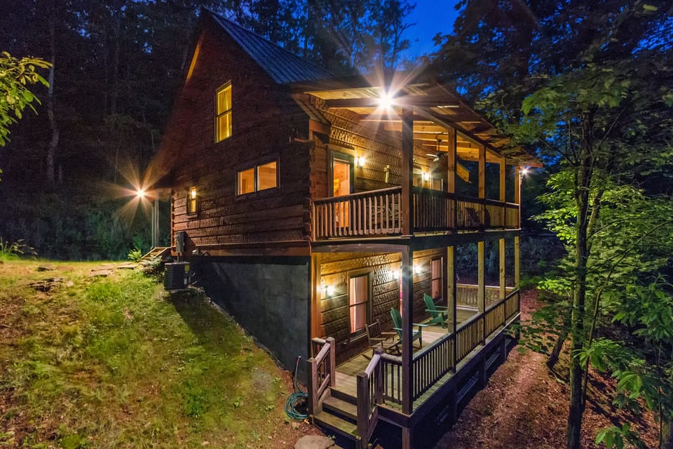 The back of Chimney Rock Cabin at night. Shows upper and lower decks