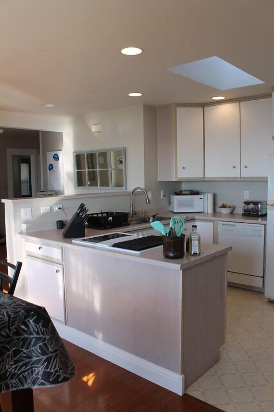 Kitchen is compact and complete with spices, oils, pots, pans, coffee maker.