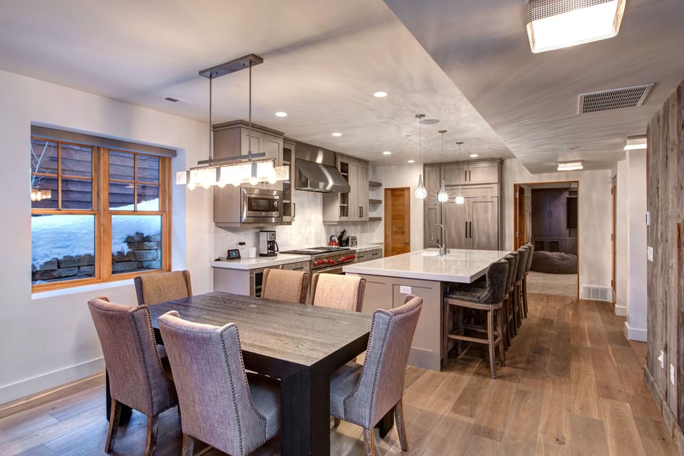 Gather in our open-concept living space, featuring a modern kitchen island with seating, a large dining table for memorable meals, and all the essentials for a great stay.