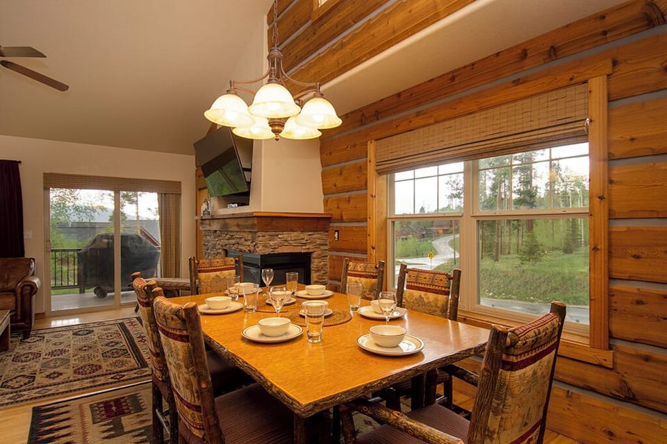 Gather around this handcrafted dining table where warm log walls and crackling fireplace create your perfect mountain retreat dining experience.