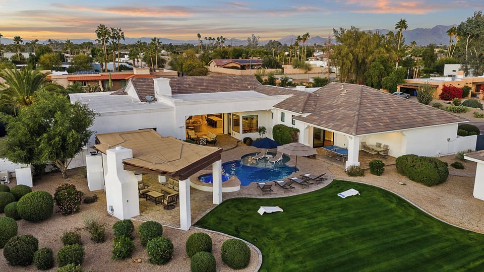 Aerial view of private estate with mountain views, pool, spa, and patio