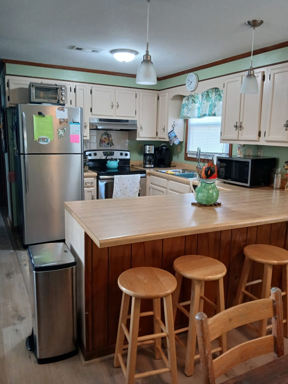 Bar seating at kitchen counter and fully equipped kitchen.