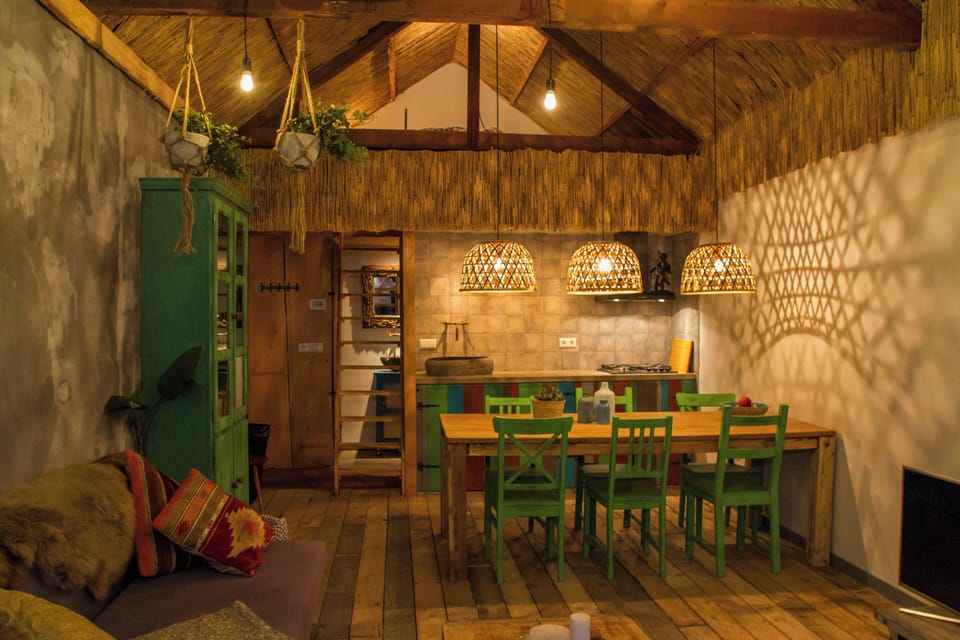 Cozy rustic dining space with wood beams, woven lights, and vibrant charm