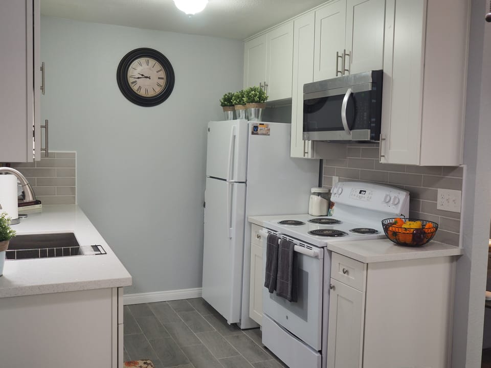 Kitchen fully equipped with cooking utensils and dishes and dishwasher