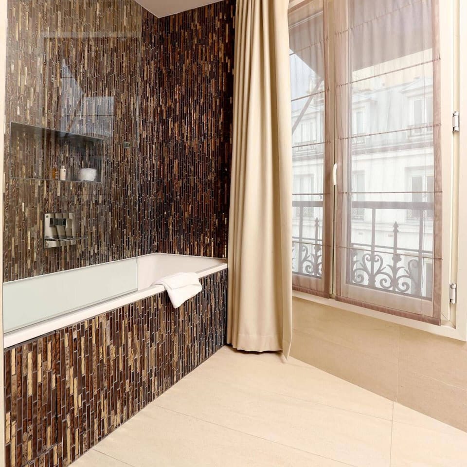 Deep soaking tub, rainfall showerhead, designer toiletries, hair dryer