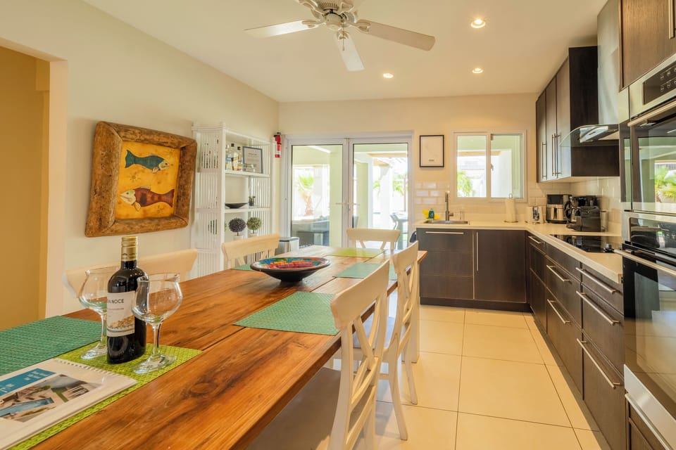 large open kitchen with all appliances and a large dining table with a view