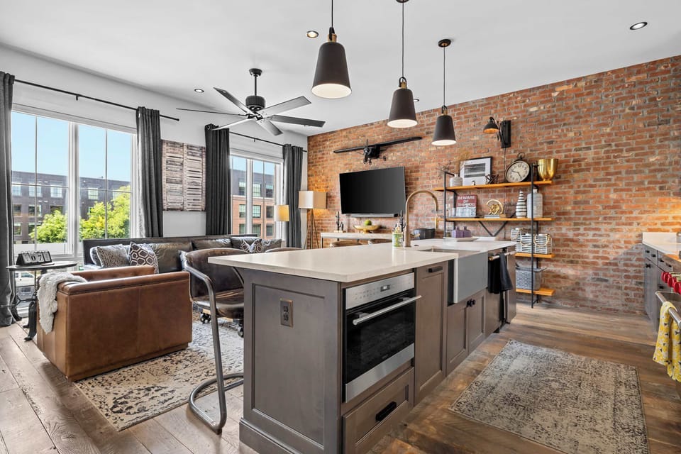 Modern, fully equipped kitchen featuring stainless steel appliances, a large island with bar seating, ample counter space, and an open-concept layout perfect for cooking and gathering together.