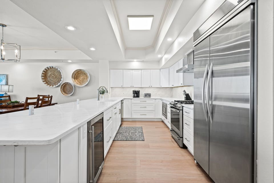 Gather, cook, and create memories in this bright, fully-equipped kitchen featuring stainless steel appliances, quartz countertops.