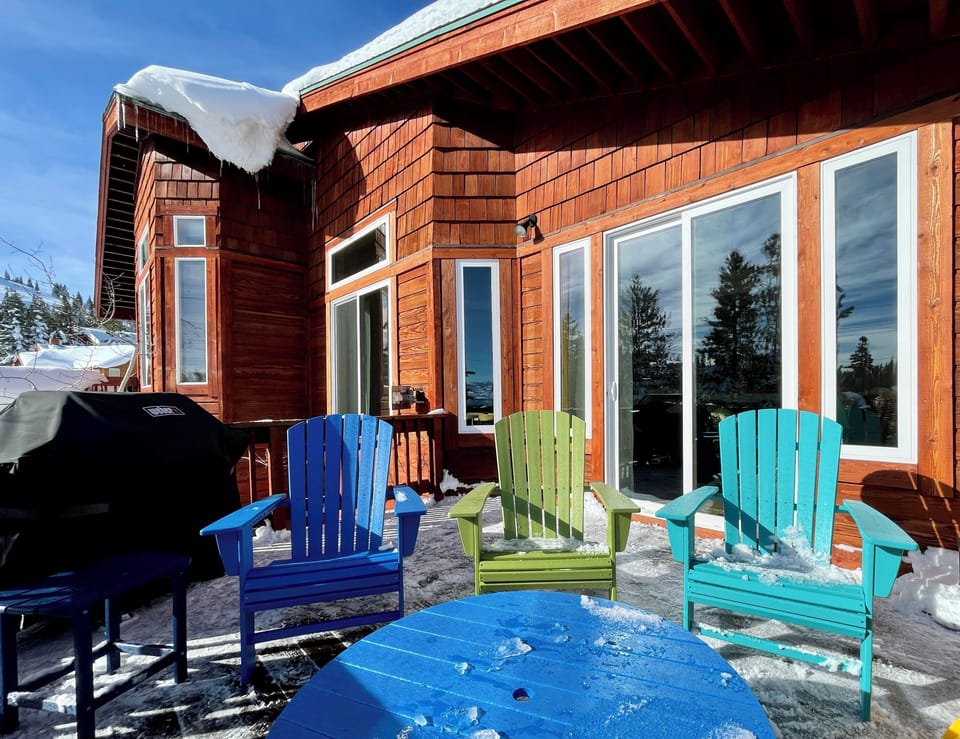 Deck with sunrise view, 3 Adirondack chairs, table, umbrella, and gas BBQ.