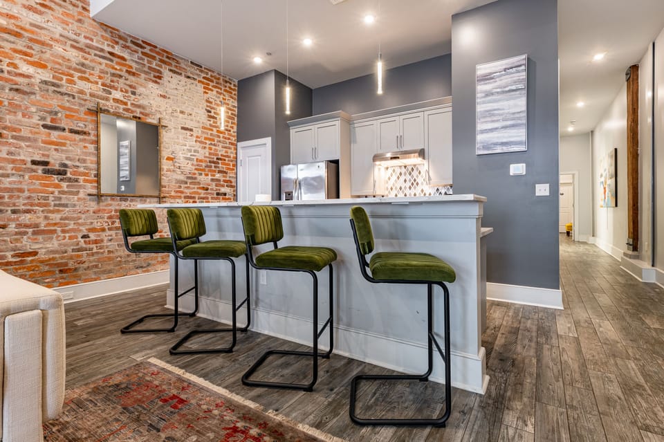 Galley-style, fully equipped kitchen with an open flow to the living/dining area. Stocked with essentials from mixing bowls to wine glasses, featuring stainless steel appliances, stone countertops, and a tile backsplash for a touch of luxury!
