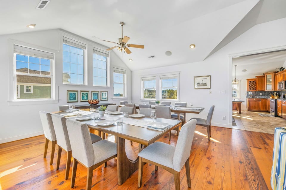 Gather around this elegant dining space where natural light streams through large windows, creating the perfect setting for memorable meals together.